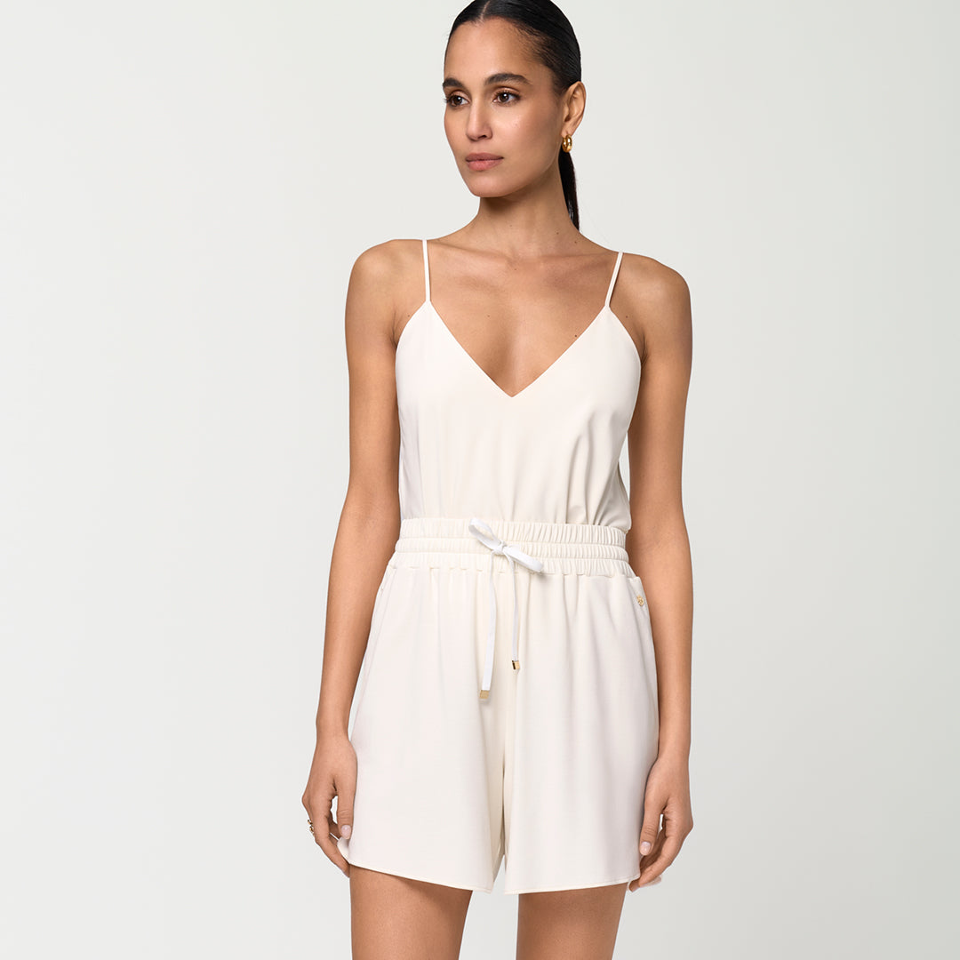 E-commerce image of a model wearing a summery outfit that consists of a strap top in the signature INA KESS colour alba, and the matching shorts. 