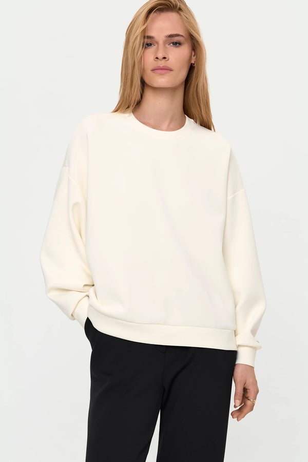 Ivory oversized crew neck sweater with black pants, cropped front view