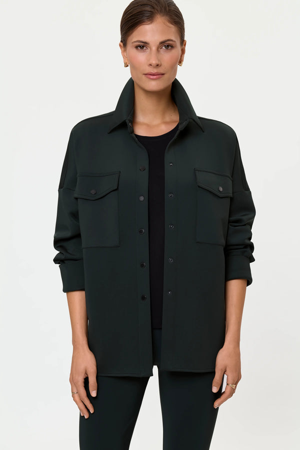 Front view of the ECIRE Shirt Jacket in Forest worn closed, emphasizing the clean button-front design, flap pockets, dropped shoulder fit, and long relaxed silhouette.