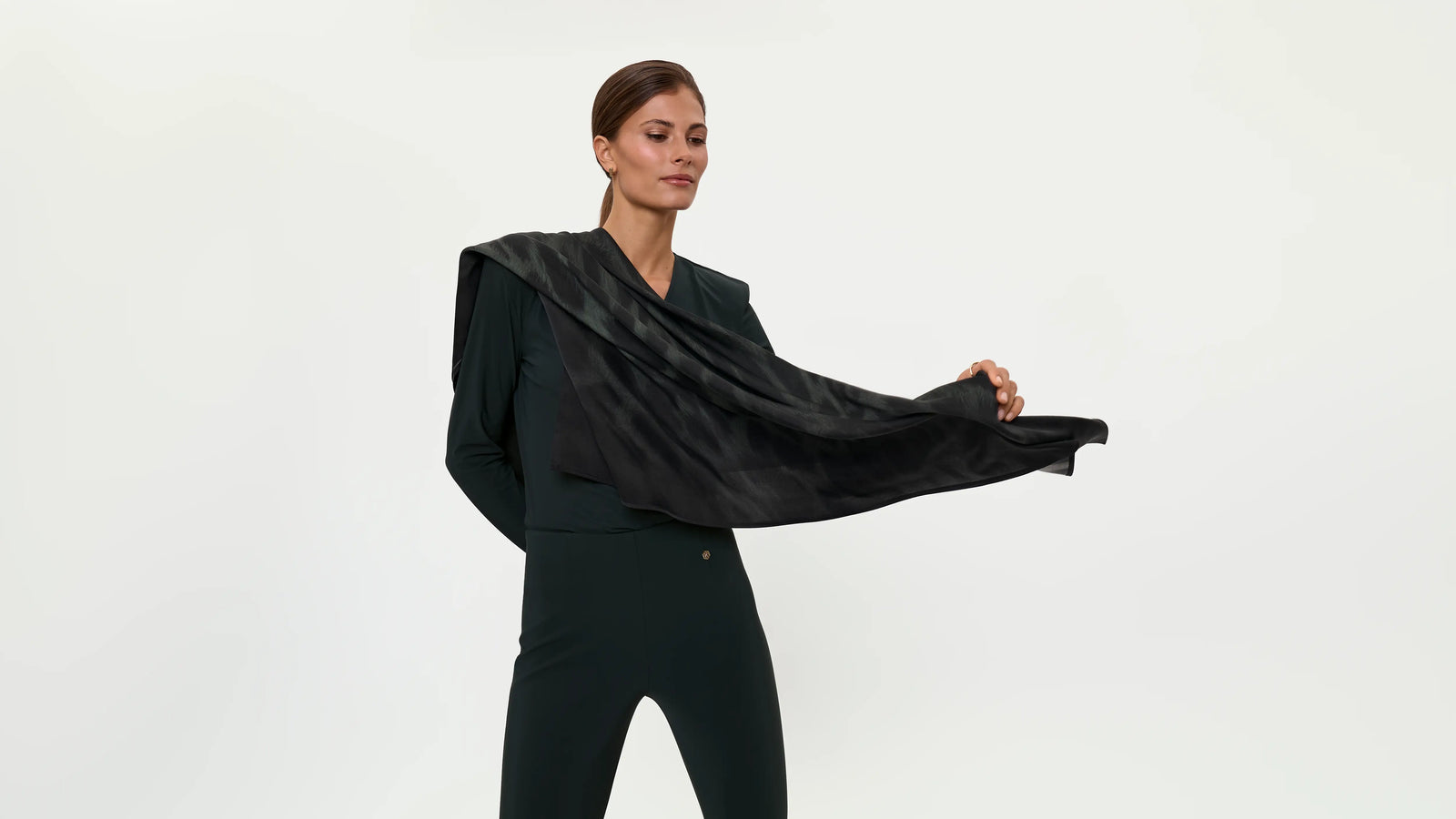 Full-length styling shot of the BAGHIRA Scarf in Diorit with the MERENDA Blouse and ELLA Stretch Pants in Forest, capturing the scarf’s length, lightweight texture, and dramatic draped movement.